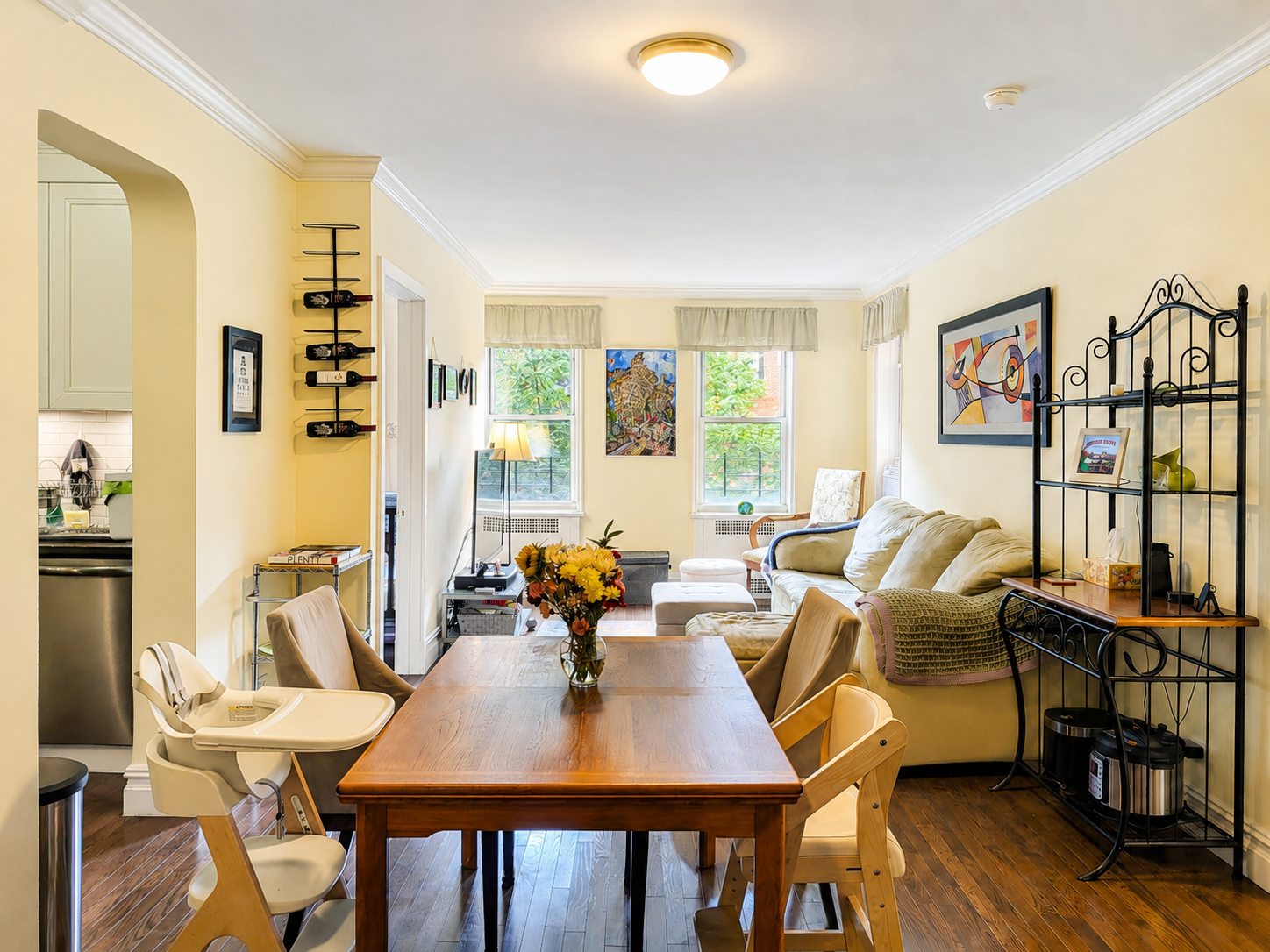 D32 living and dining room with three windows and leafy treetop views