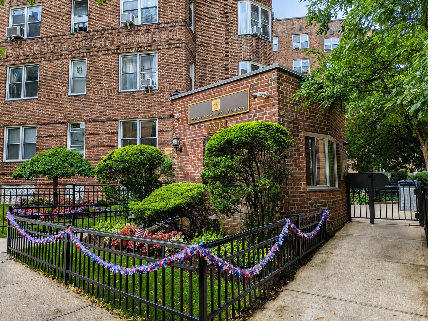 Landscaped gatehouse entrance to Washington Plaza at 73-12 35th Avenue